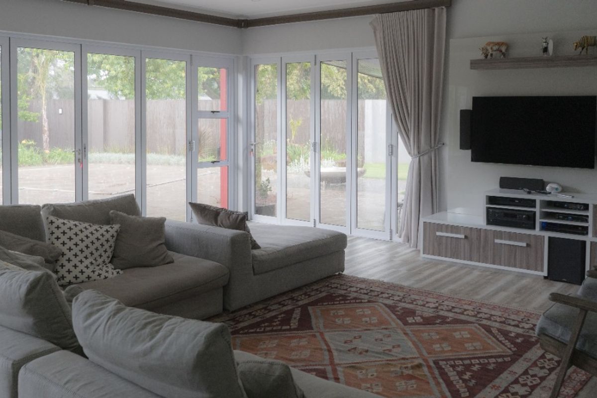 Spacious living room featuring large glass sliding doors that provide abundant natural light and seamless access to the outdoor garden area.