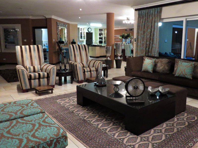 Spacious open-plan living area featuring tiled flooring, recessed lighting, and seamless flow to the kitchen and dining space with large sliding glass doors.