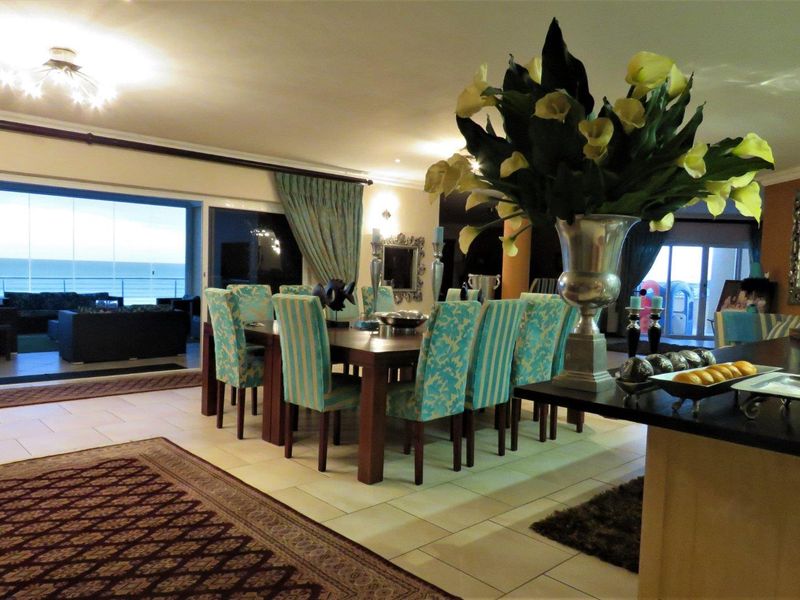 Spacious open-plan living and dining area featuring large sliding glass doors that provide seamless access to the balcony and ocean views.