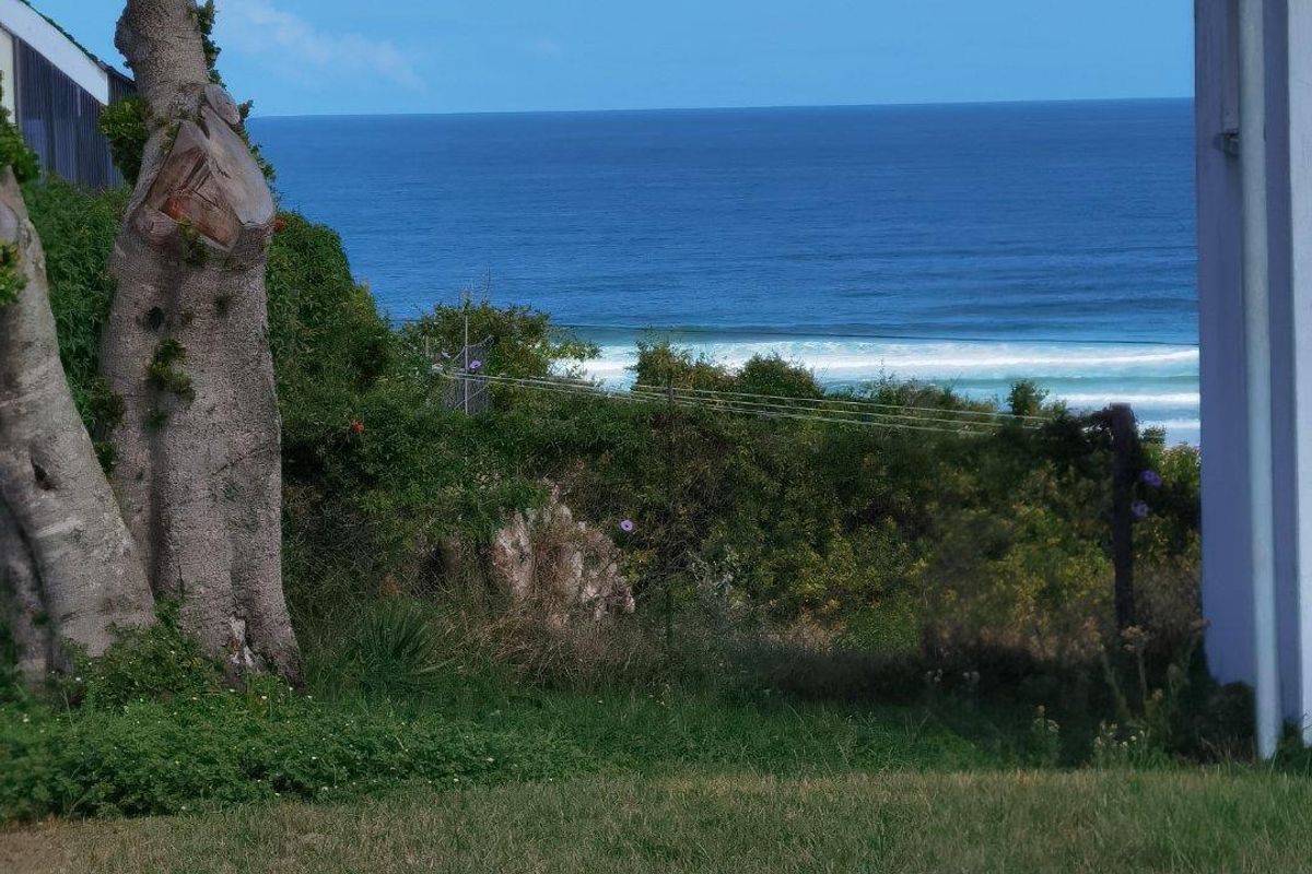 A scenic view of the ocean and coastline captured from the property grounds, showcasing the natural landscape and coastal horizon.