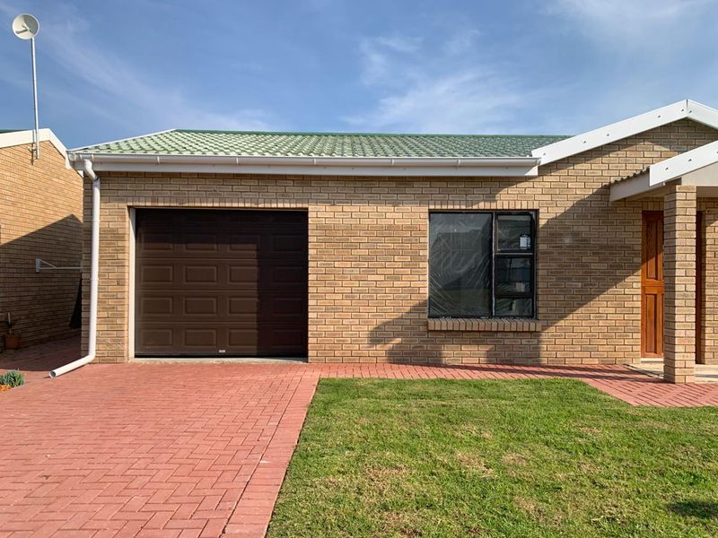 Front elevation of a retirement village unit featuring a brick facade, tiled roof, paved driveway, and a single garage.