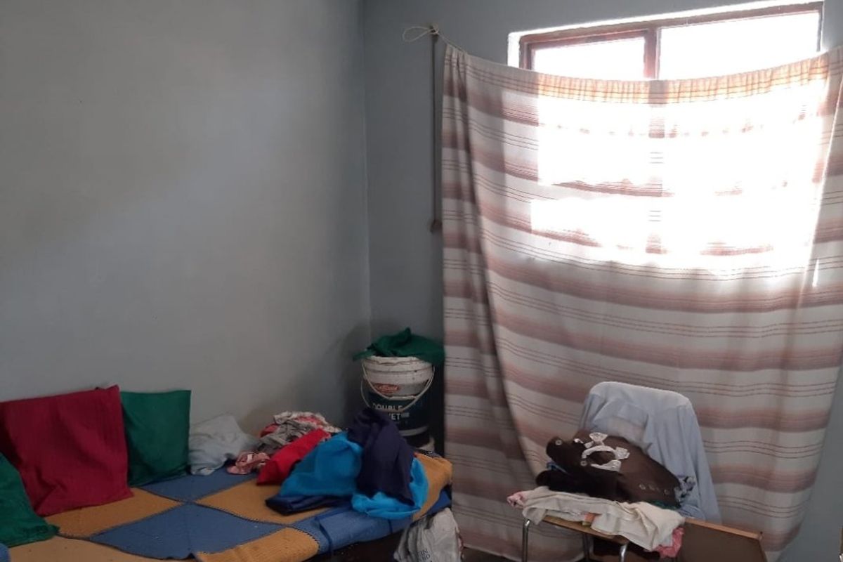 A bedroom space featuring basic wall finishes and a window, requiring cosmetic updates and maintenance to improve the overall condition and appeal.