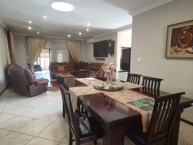 Spacious open-plan living and dining area featuring ceramic tiled flooring, recessed lighting, and sliding door access to the outdoor patio.