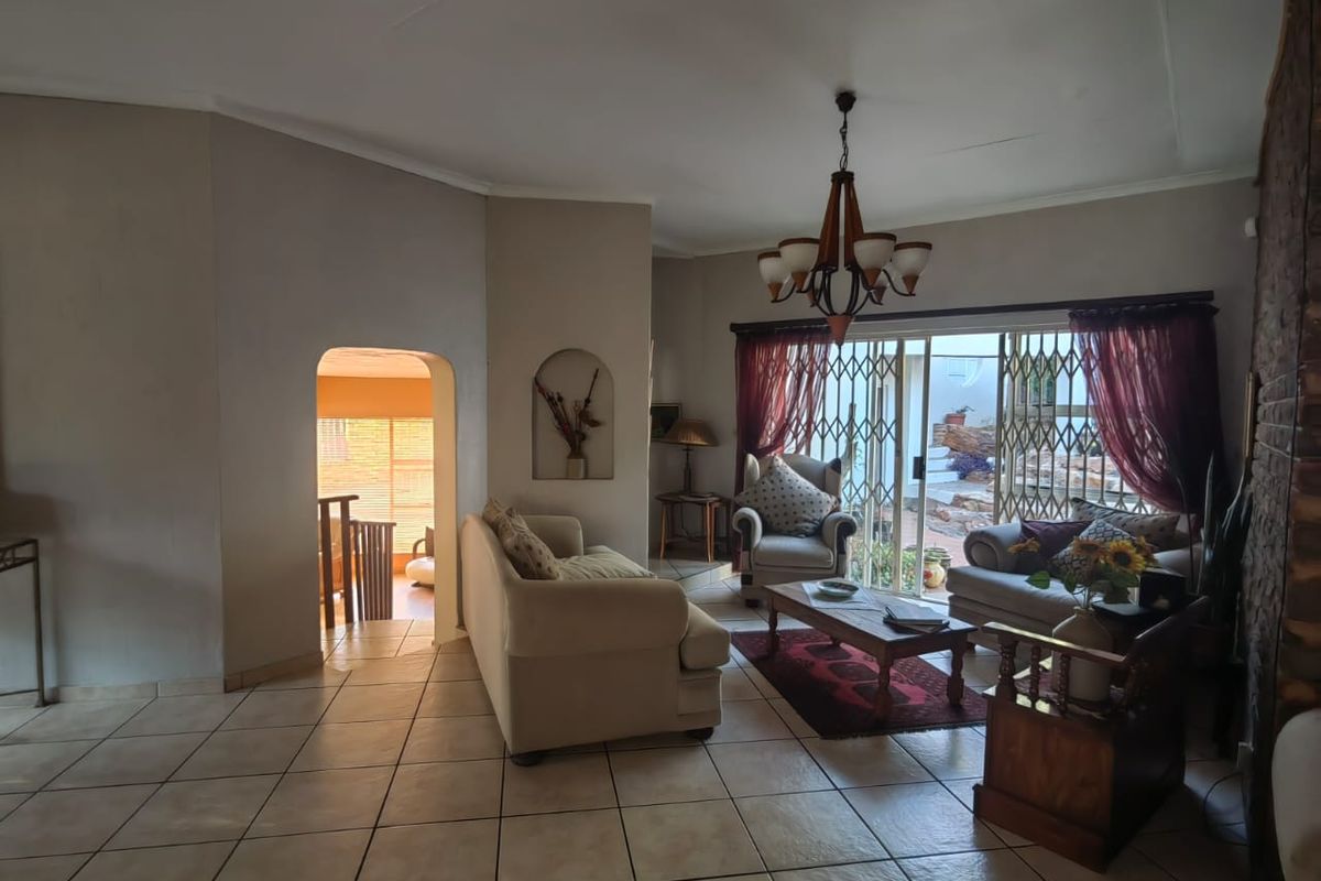 Spacious living room featuring tiled flooring, a decorative wall niche, and sliding glass doors providing direct access to the outdoor patio area.
