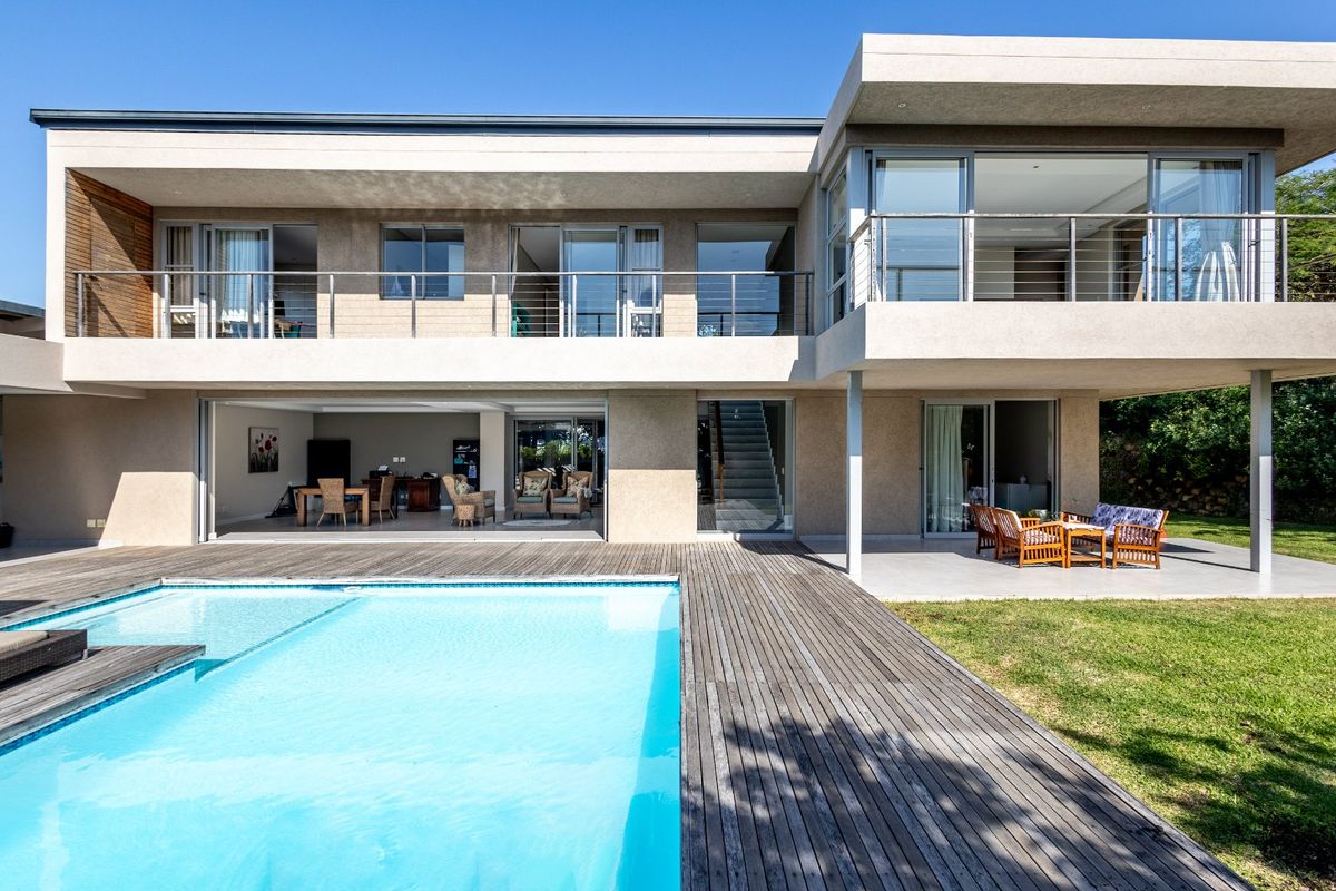 Modern double-story residence featuring a swimming pool, expansive timber decking, and a covered patio area with seamless indoor-outdoor flow.