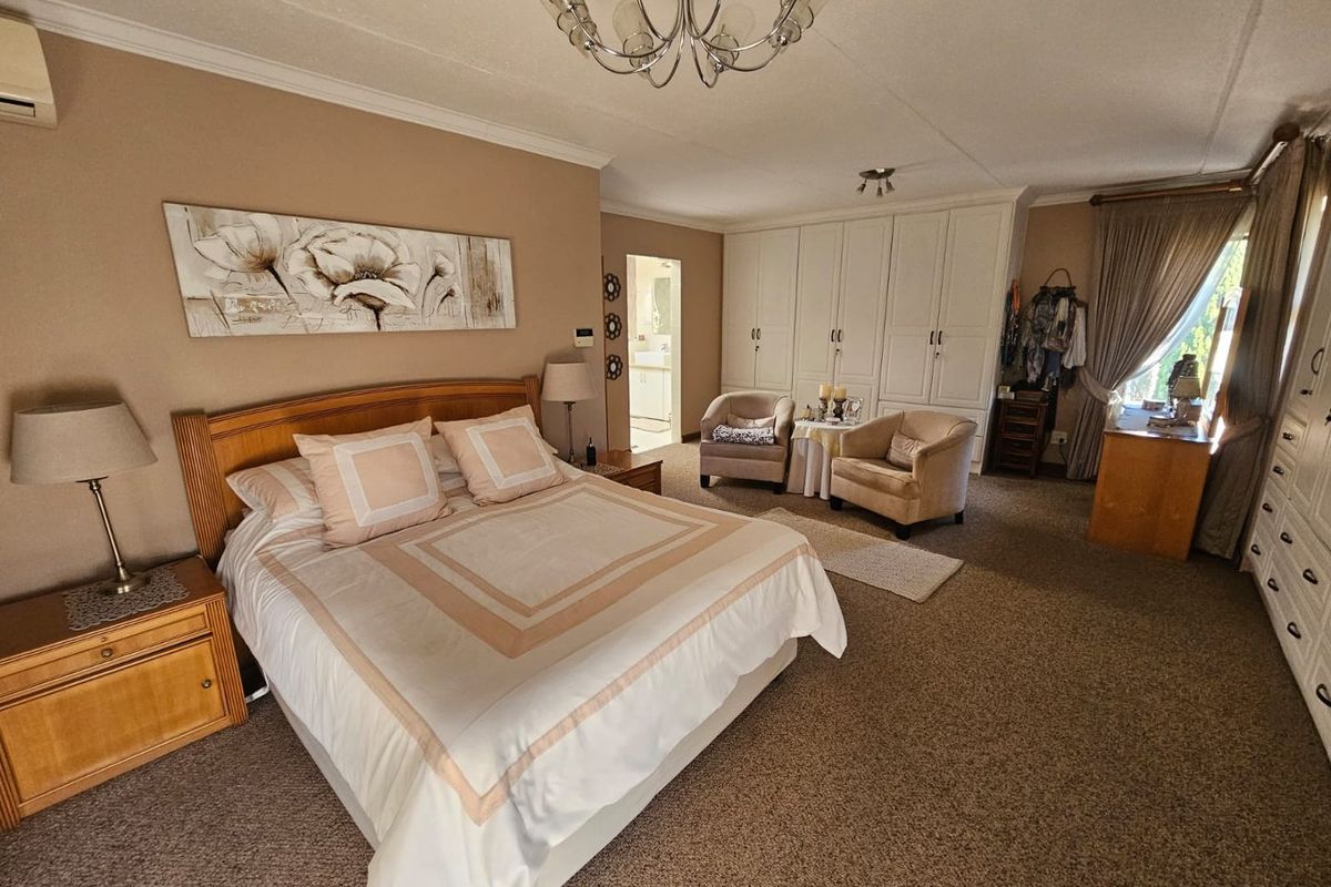 Spacious bedroom featuring extensive built-in cabinetry, neutral wall tones, and an en-suite bathroom access point.