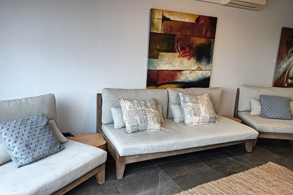 A comfortable living area featuring dark tiled flooring and a wall-mounted split-system air conditioning unit.