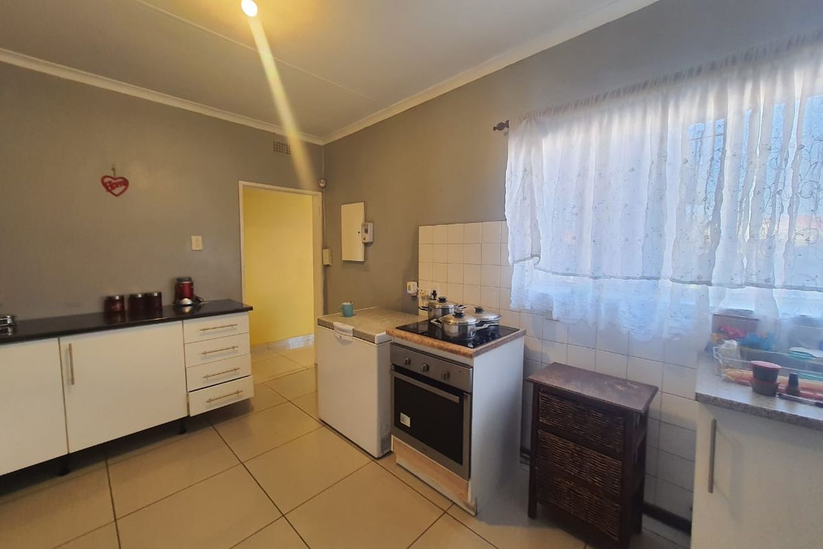 Functional kitchen featuring tiled flooring, built-in cabinetry, and a freestanding stove with oven, offering a practical layout for daily meal preparation.