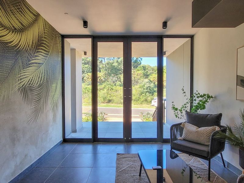 Modern entrance hall featuring large glass sliding doors that provide ample natural light and a seamless transition to the outdoor area.