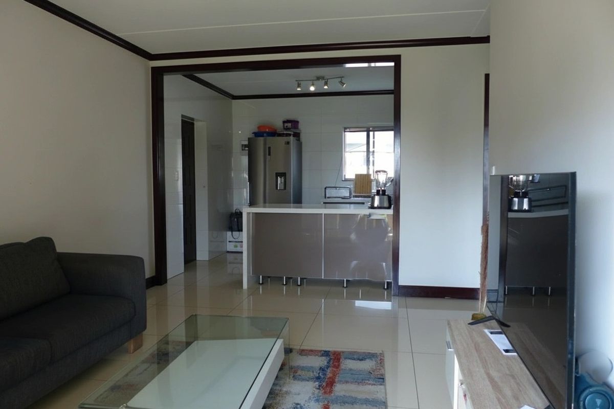 Open plan living area featuring tiled flooring and a kitchen with a central island and built-in cabinetry.