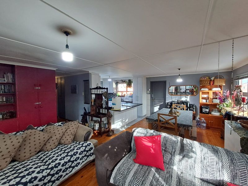 Open-plan living and dining area featuring hardwood flooring, built-in cabinetry, and a central kitchen island, creating a functional and connected living space.