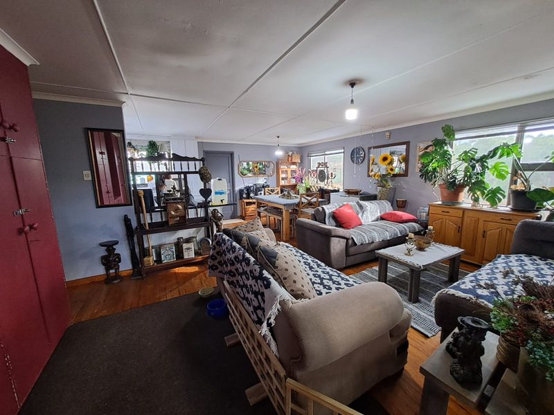 Spacious open-plan living and dining area featuring hardwood flooring and neutral wall tones, offering a versatile layout for family living.