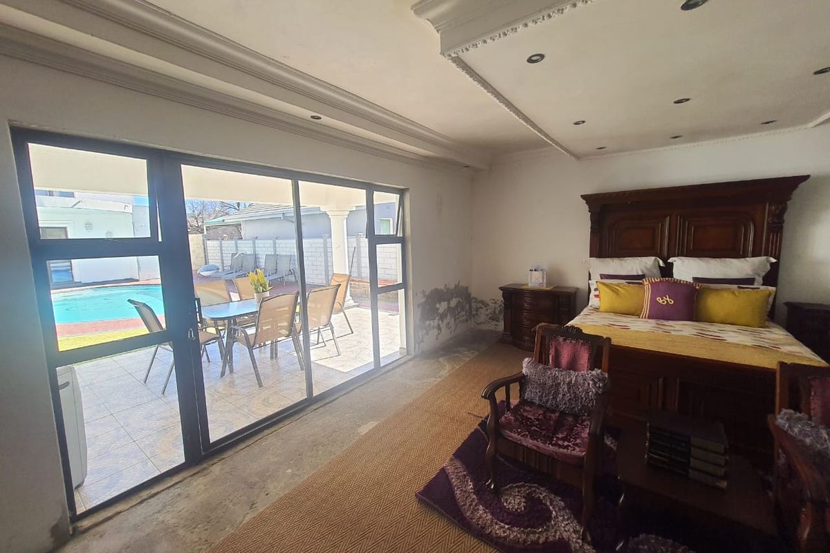 Spacious bedroom featuring large sliding glass doors with direct access to the patio and pool area, offering natural light and outdoor connectivity.