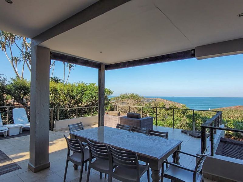 Spacious covered patio featuring tiled flooring, recessed lighting, and a metal balustrade, offering expansive ocean views and an ideal outdoor entertainment space.