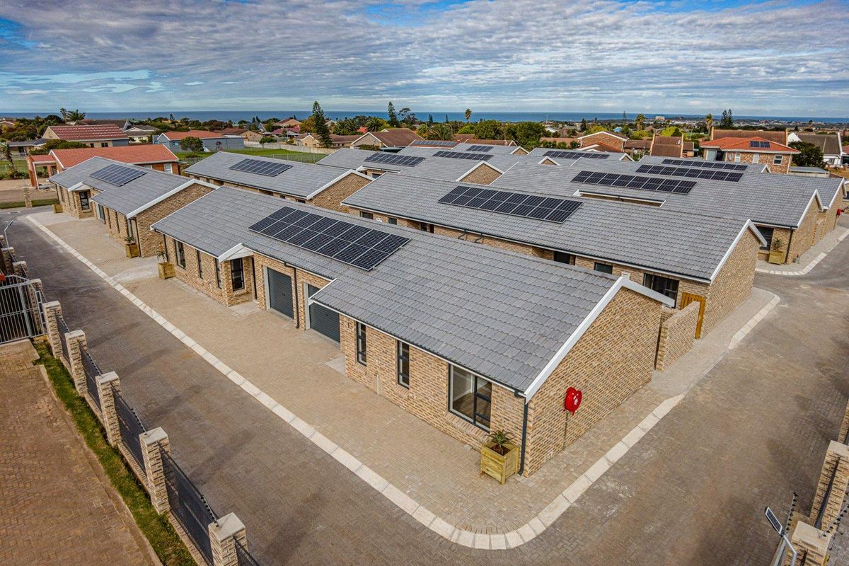 Aerial view of a modern townhouse complex featuring face-brick facades, tiled roofs, and integrated solar panel installations.