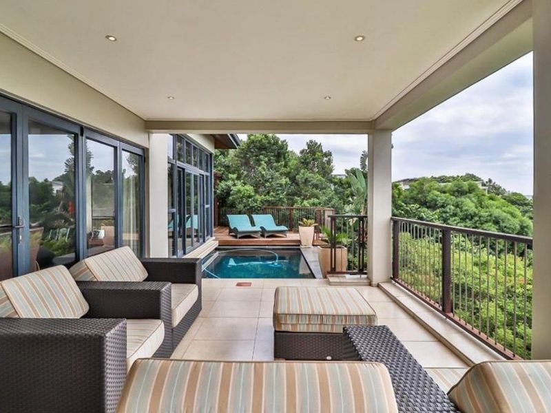 Covered patio area featuring tiled flooring, recessed lighting, and direct access to a private plunge pool with scenic garden views.