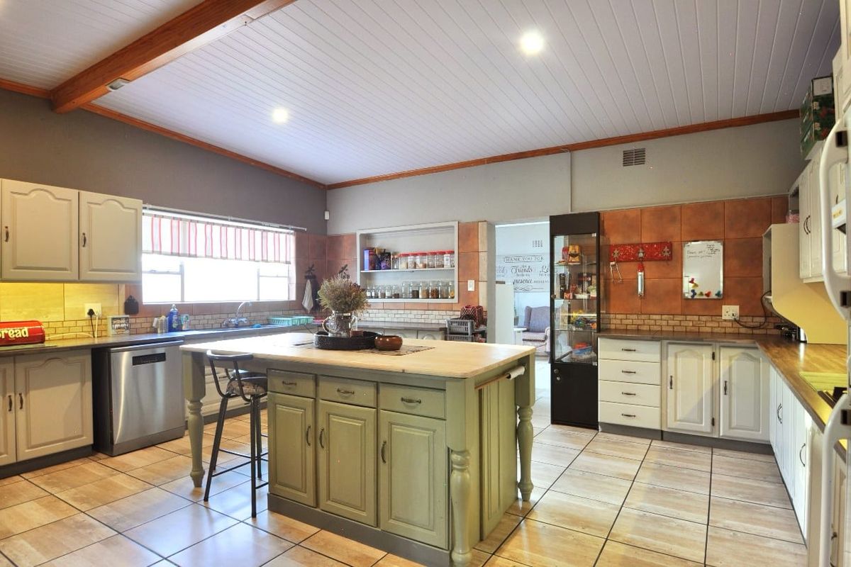 Spacious kitchen featuring a central island, tiled flooring, built-in cabinetry, and recessed lighting, offering a functional layout for cooking and casual dining.