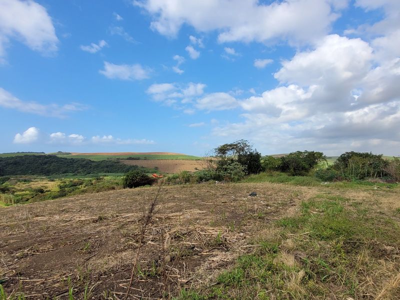 Expansive view of the surrounding rural landscape and rolling hills, showcasing the natural terrain of the farm property.