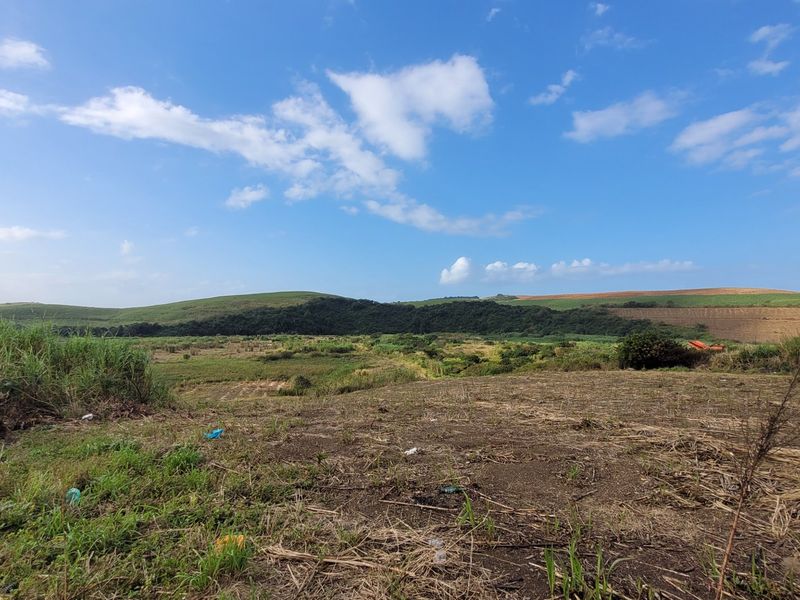 Expansive view of the surrounding farm landscape, featuring rolling hills and natural vegetation.