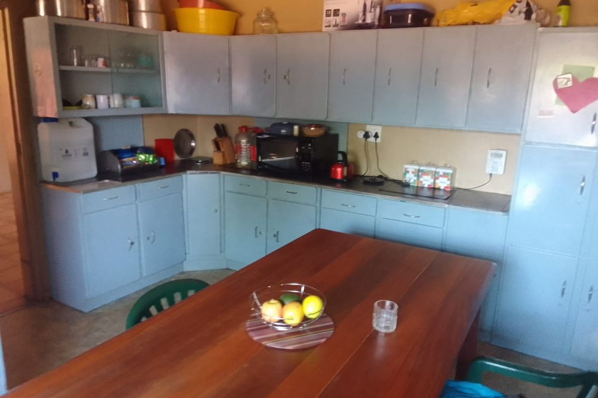 A functional kitchen featuring extensive built-in cabinetry and laminate countertops, offering ample storage space but requiring cosmetic updates to modernize the interior finishes.