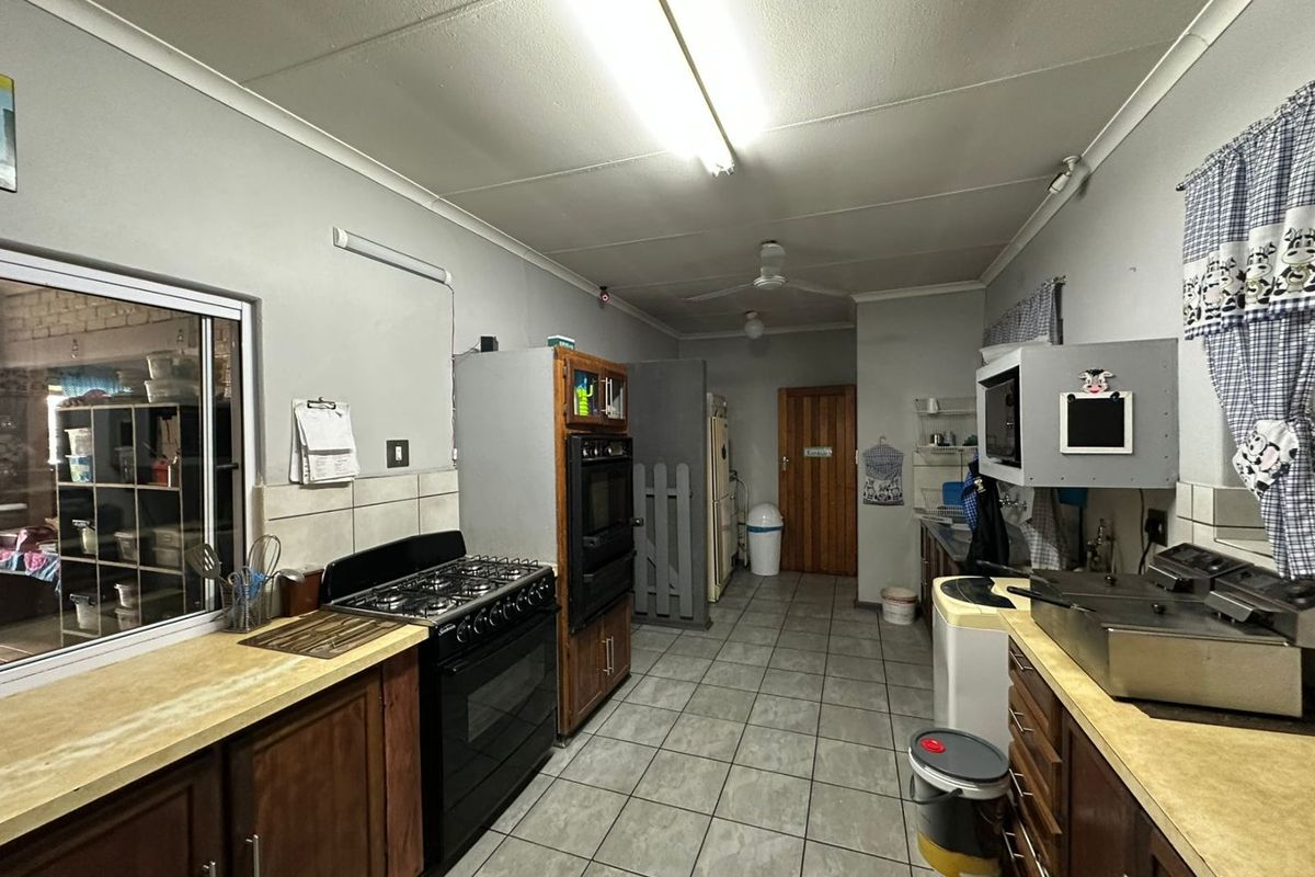 Functional kitchen featuring wooden cabinetry, a gas stove, built-in oven, and tiled flooring with ample counter space for meal preparation.