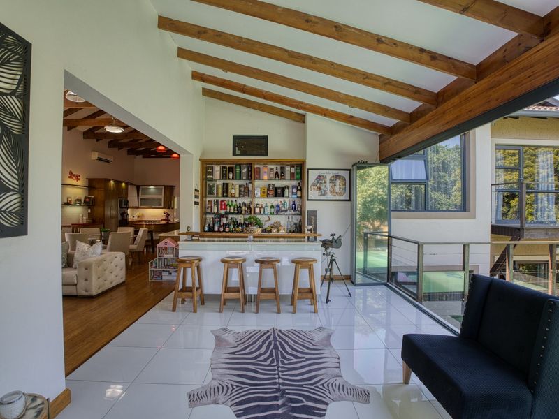 Spacious bar area featuring a built-in counter, exposed timber ceiling beams, and large sliding glass doors opening to an outdoor view.