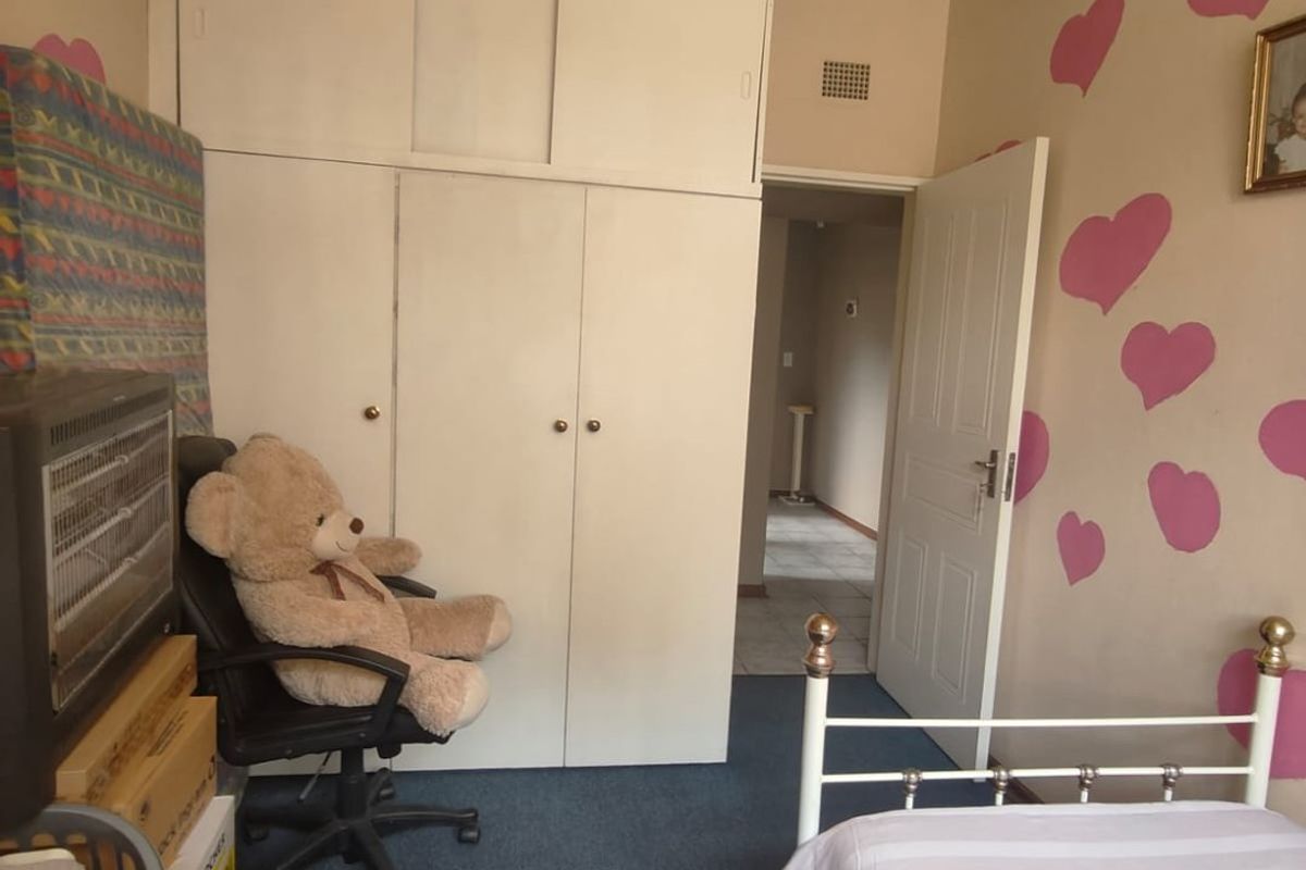 A bedroom featuring built-in cupboards, carpeted flooring, and a white timber-paneled ceiling.