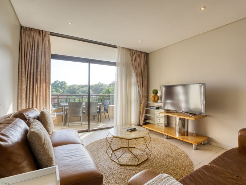 Bright living room featuring tiled flooring, recessed lighting, and large sliding glass doors providing seamless access to an outdoor balcony area.