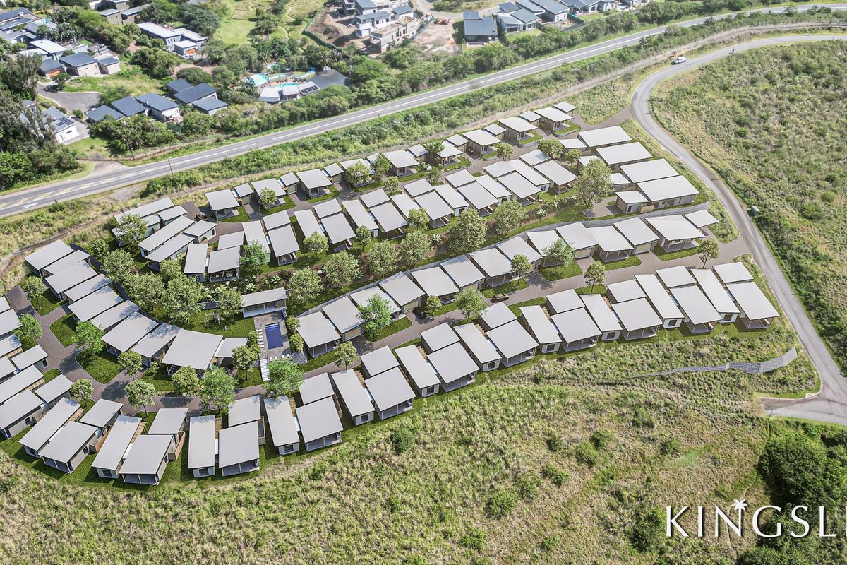 An aerial view of the Kingsley residential development, showcasing the layout of multiple housing units, communal pool area, and surrounding landscaped grounds.
