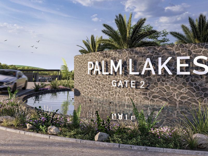 The entrance to Palm Lakes Gate 2 features a prominent stone-clad signage wall, a decorative water feature, and professional landscaping.