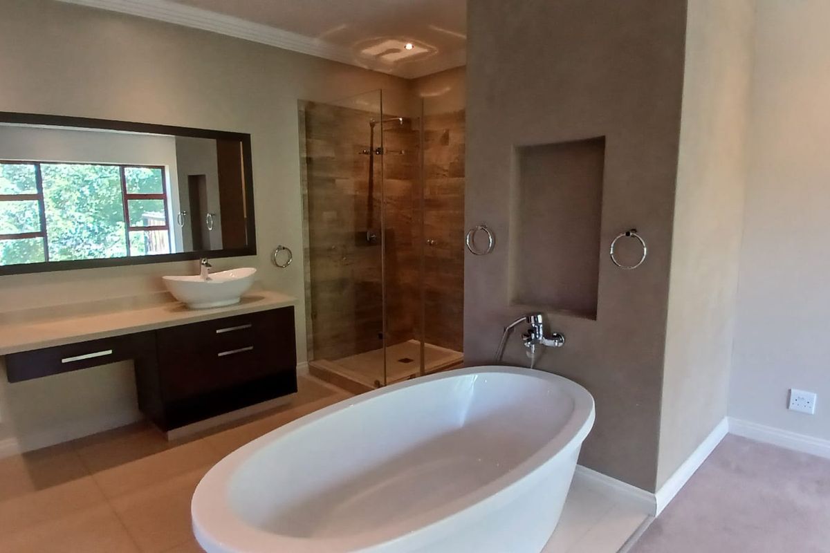 Modern bathroom featuring a freestanding bathtub, a glass-enclosed walk-in shower, and a floating vanity with a vessel sink.