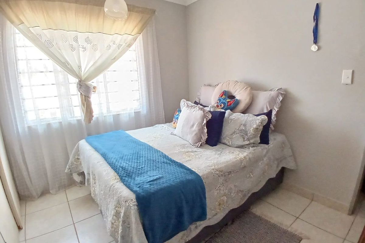 A functional bedroom featuring tiled flooring and a window with natural light, providing a simple and comfortable living space.