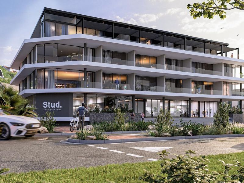 A modern multi-story apartment building featuring expansive glass facades, private balconies, and ground-floor commercial space in a contemporary architectural style.