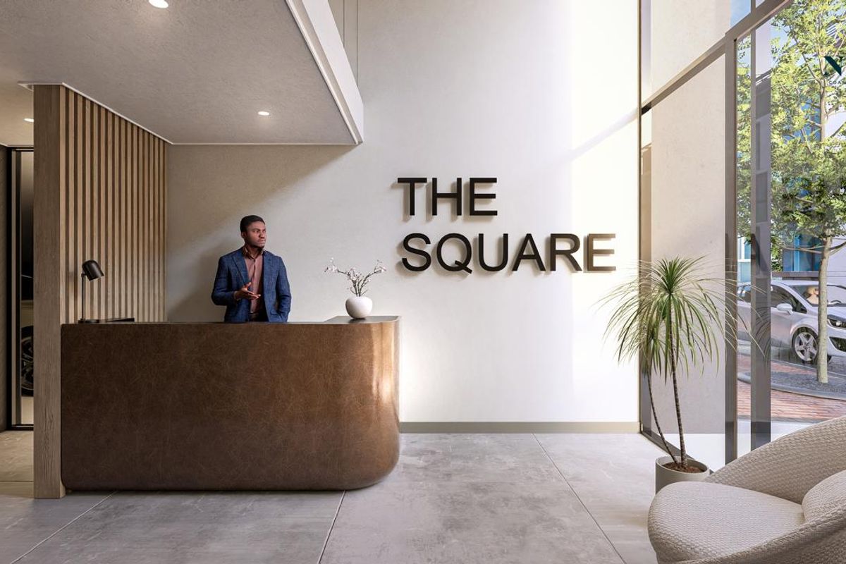 Modern reception area featuring a sleek built-in concierge desk, floor-to-ceiling glass windows, and contemporary architectural finishes in a professional building lobby.