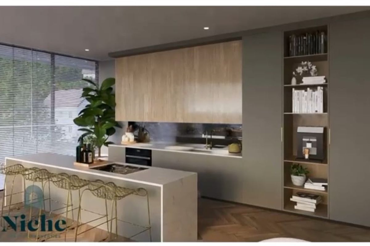 Modern open-plan kitchen featuring sleek cabinetry, a stone-topped island with integrated cooktop, and floor-to-ceiling storage shelving.