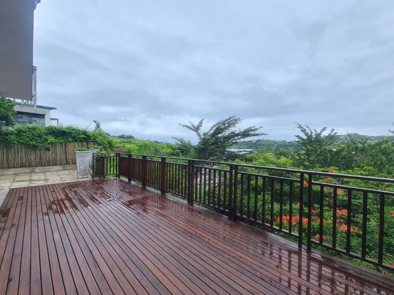 Spacious outdoor timber deck featuring a wooden balustrade and scenic views, providing an ideal area for outdoor relaxation and entertainment.