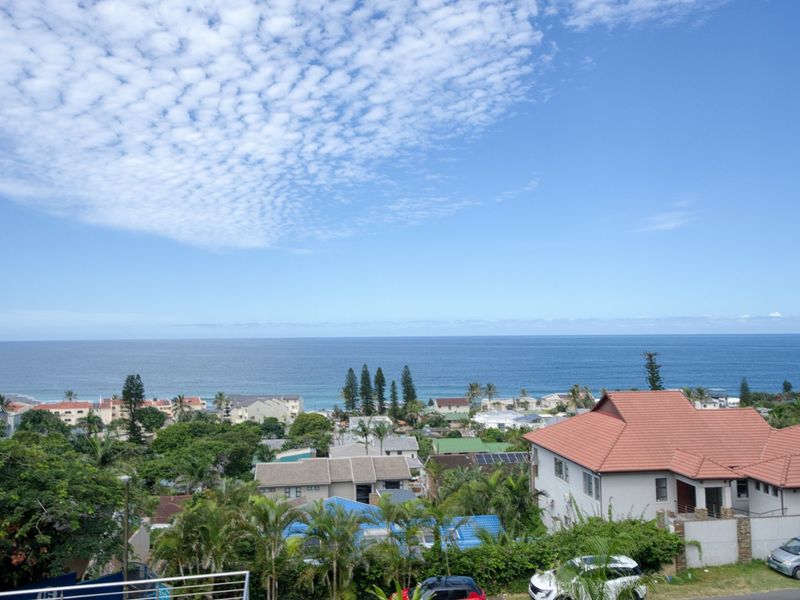 A scenic elevated view overlooking the coastal neighborhood and the ocean horizon.