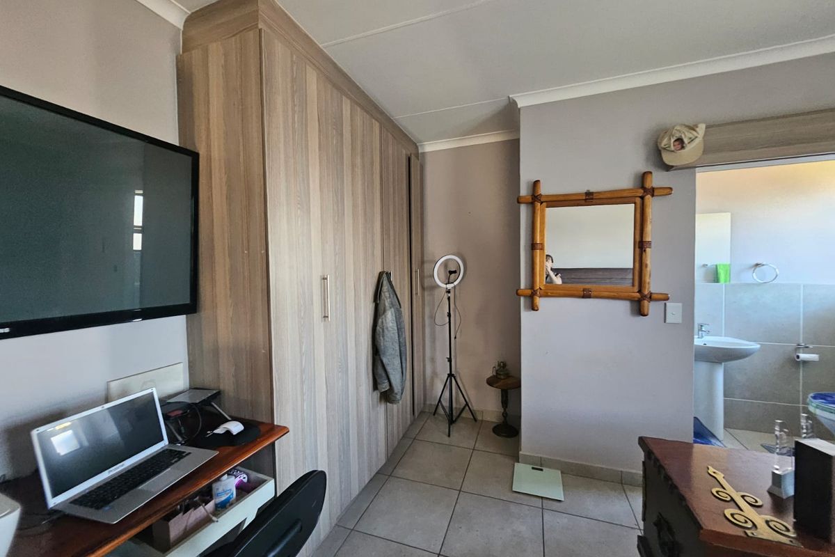 Bedroom featuring built-in wooden cabinetry, tiled flooring, and an en-suite bathroom access.