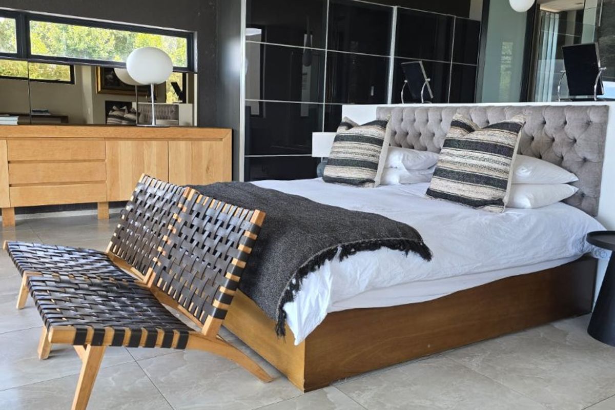 Spacious bedroom featuring large format floor tiles, recessed ceiling lighting, and integrated floor-to-ceiling storage cabinetry.