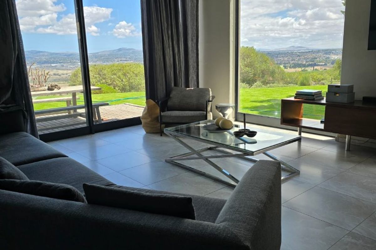 Spacious living area featuring floor-to-ceiling windows and sliding glass doors that offer expansive views of the surrounding landscape and garden.