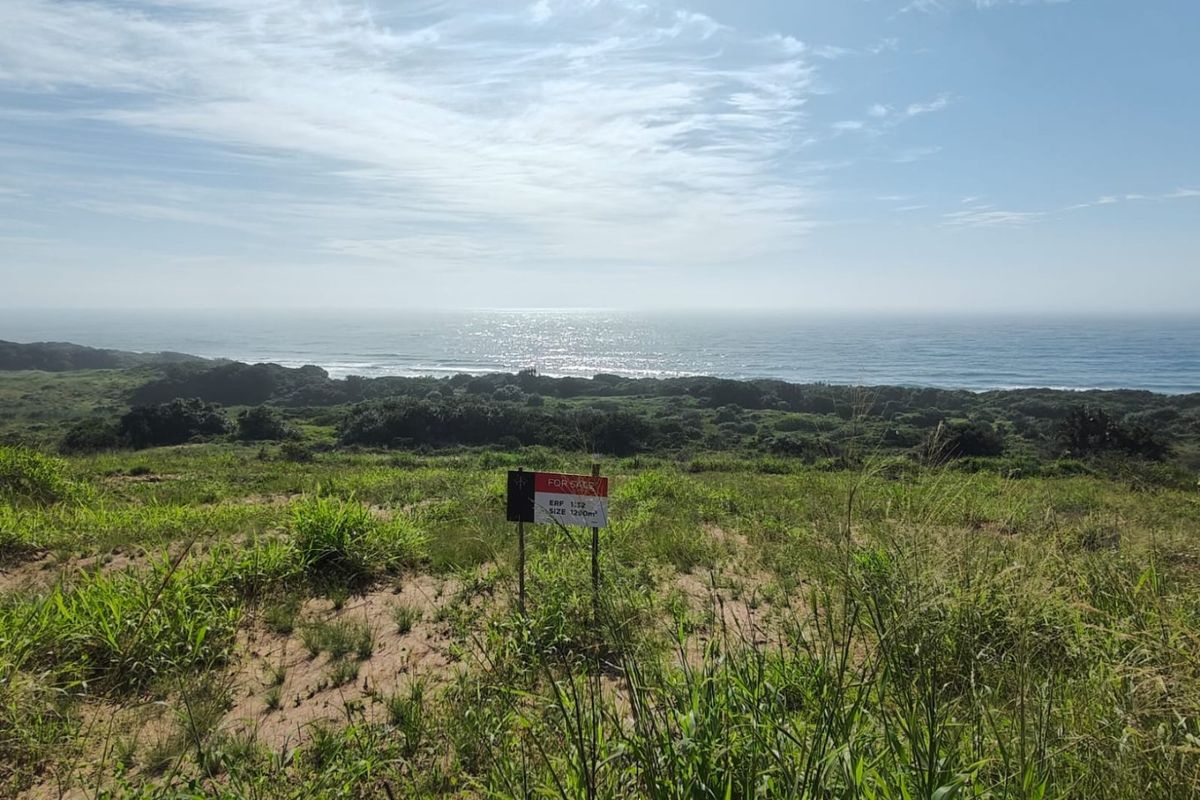 A vacant residential plot featuring expansive, elevated ocean views and natural coastal vegetation.