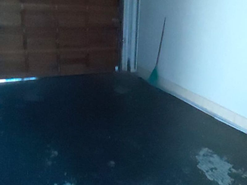 A single garage space featuring a sectional door and an automated motor, with visible wear on the concrete flooring.