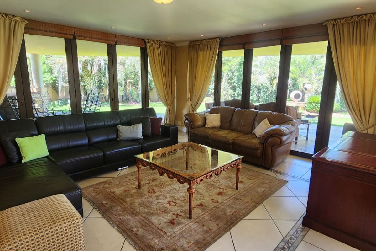 Spacious living room featuring large floor-to-ceiling glass sliding doors that provide abundant natural light and direct access to the outdoor garden area.