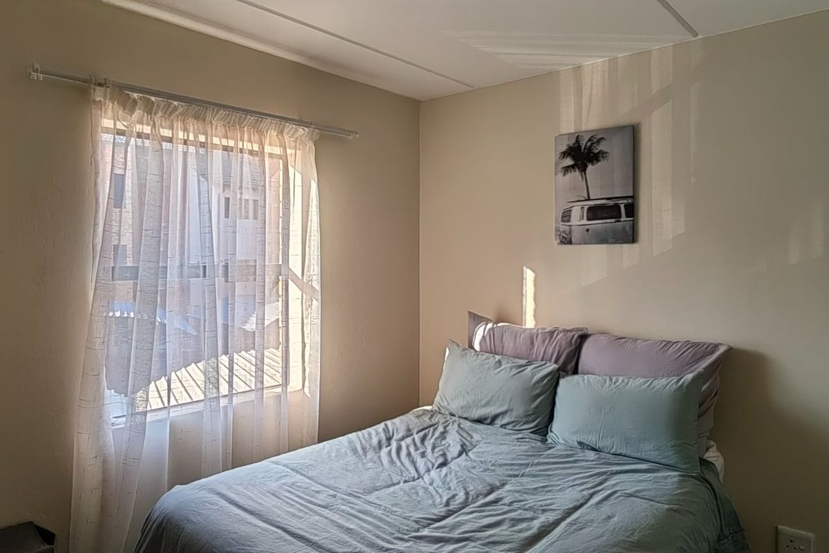 A functional bedroom featuring a window with natural light and standard electrical fixtures.