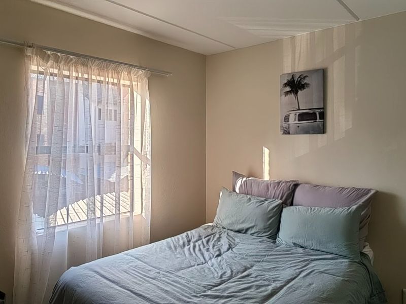 A functional bedroom featuring a window with natural light and standard electrical fixtures.