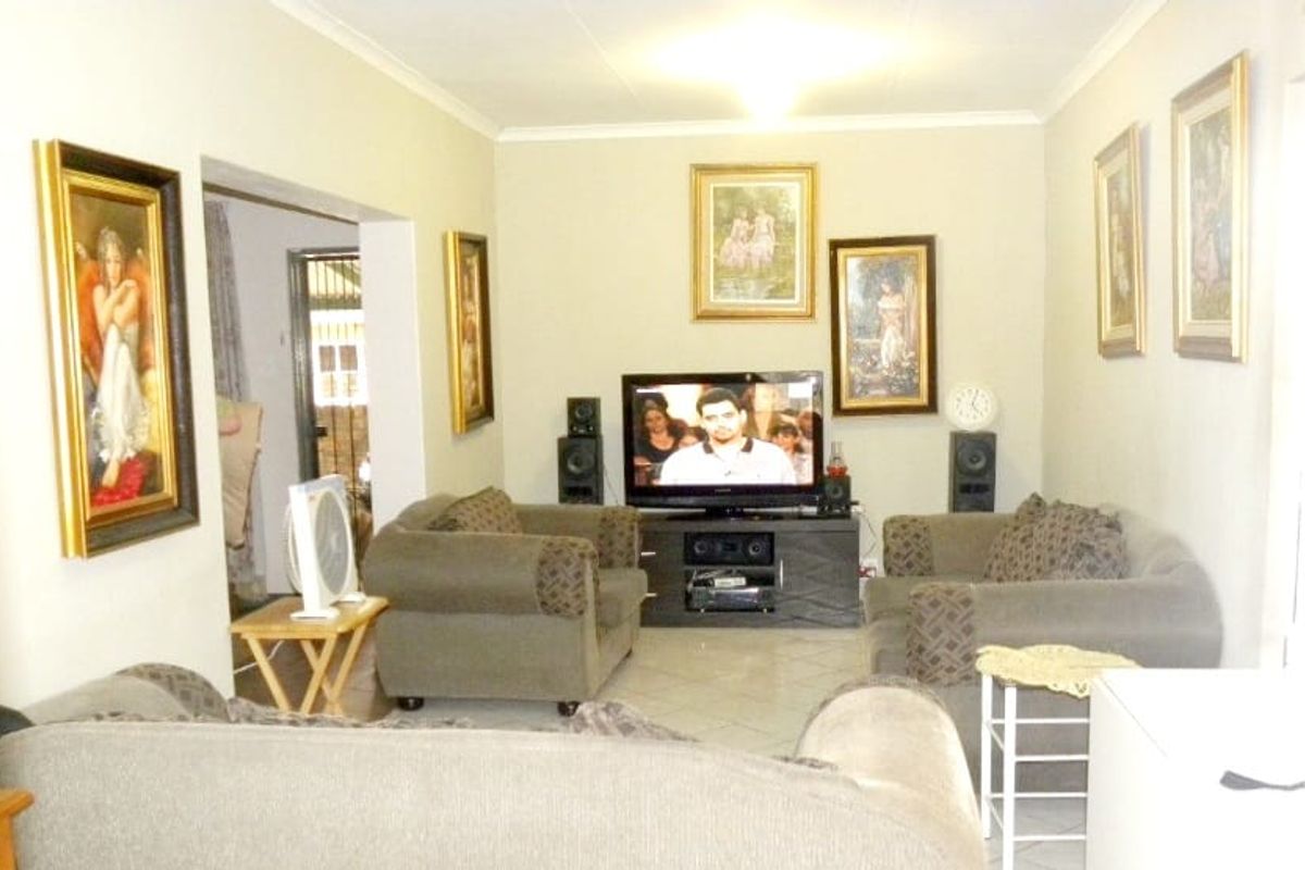A comfortable living room featuring tiled flooring and neutral wall tones, providing a functional space for relaxation and entertainment.
