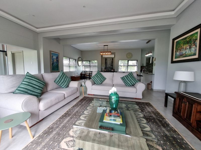 Spacious open-plan living and dining area featuring neutral tones, recessed ceiling details, and a seamless transition to the kitchen space.