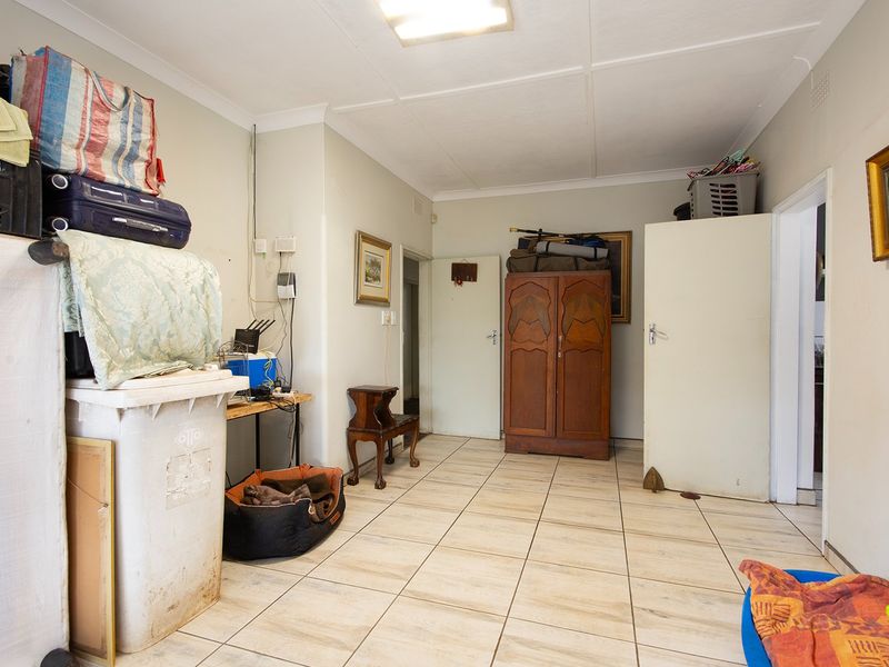 A functional interior space featuring tiled flooring and multiple doorways, suitable for use as a utility area or hallway.