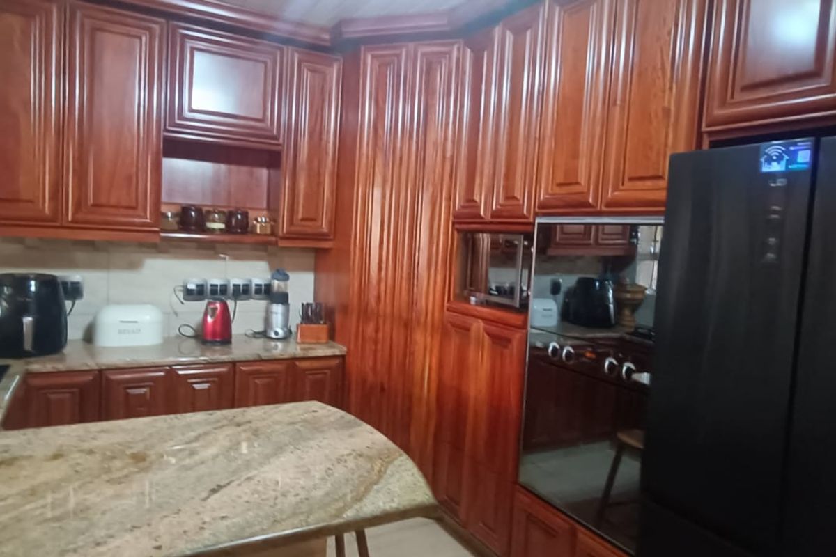 A traditional kitchen featuring extensive dark wood cabinetry, granite countertops, and a built-in oven, offering ample storage and workspace.