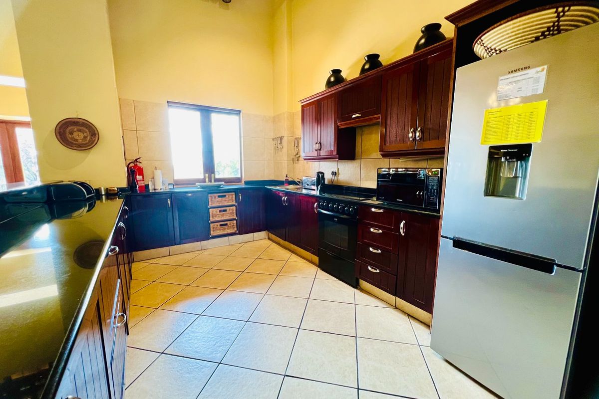 A functional kitchen featuring dark wood cabinetry, granite countertops, tiled flooring, and built-in appliances, offering a classic and practical workspace.